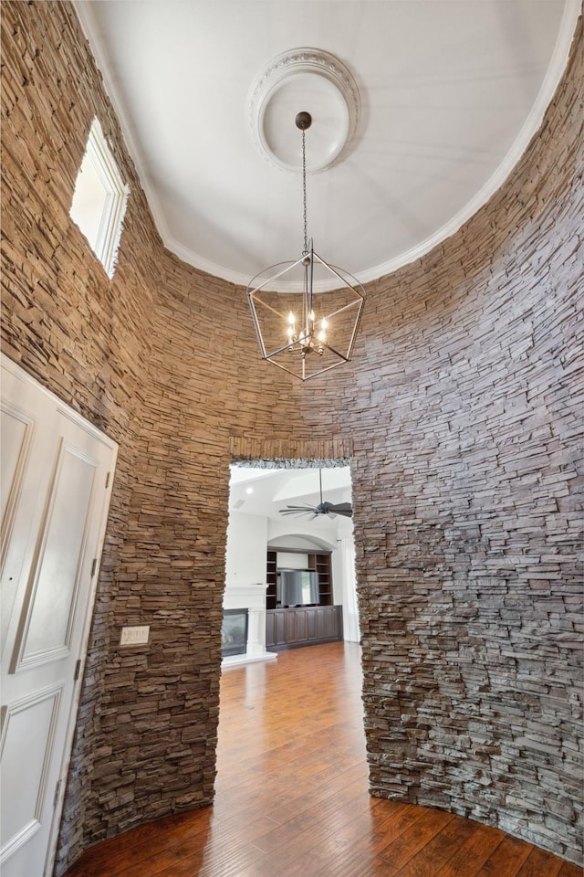 interior space featuring hardwood / wood-style flooring, a high ceiling, and ceiling fan with notable chandelier