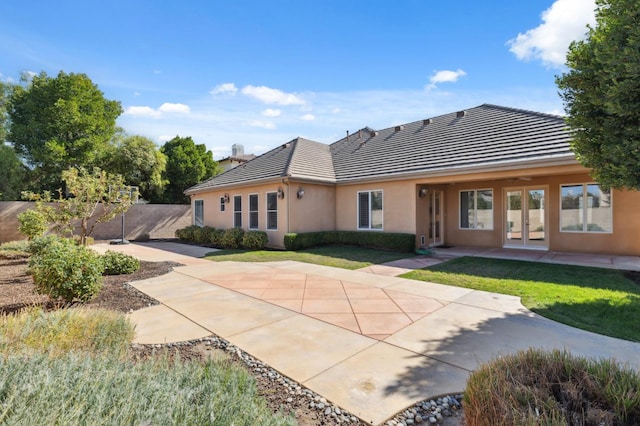 rear view of property featuring a patio area and a lawn