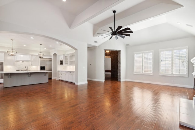 unfurnished living room featuring lofted ceiling, dark hardwood / wood-style floors, crown molding, and ceiling fan