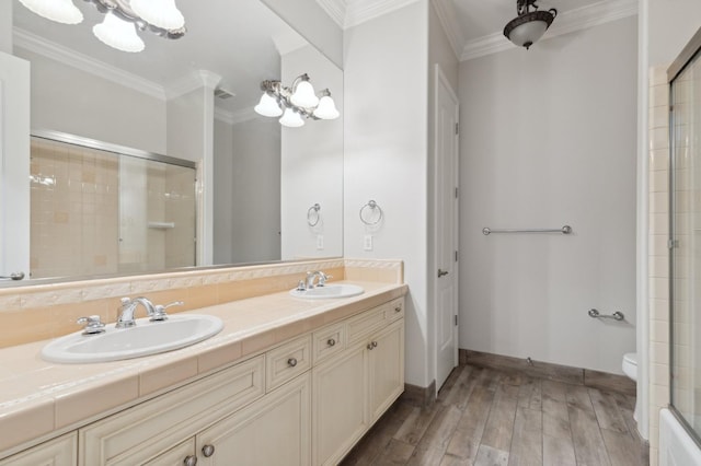 bathroom with toilet, wood-type flooring, ornamental molding, vanity, and walk in shower