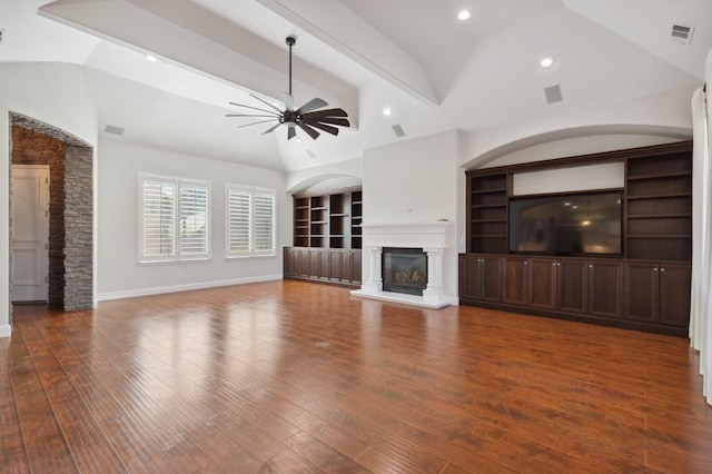 unfurnished living room with vaulted ceiling with beams, dark hardwood / wood-style floors, and ceiling fan