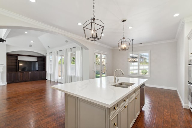 kitchen featuring sink, a kitchen island with sink, dark wood-type flooring, and pendant lighting