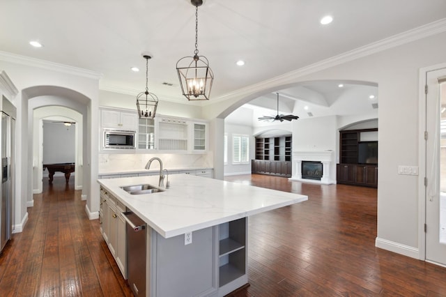 kitchen with sink, an island with sink, dark hardwood / wood-style flooring, white cabinetry, and stainless steel appliances