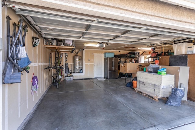 garage with a garage door opener, freestanding refrigerator, and secured water heater