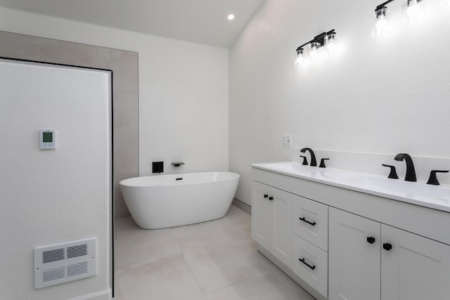 bathroom with double vanity, a soaking tub, a sink, and visible vents