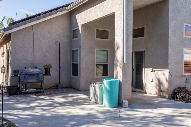 back of property featuring a patio and stucco siding