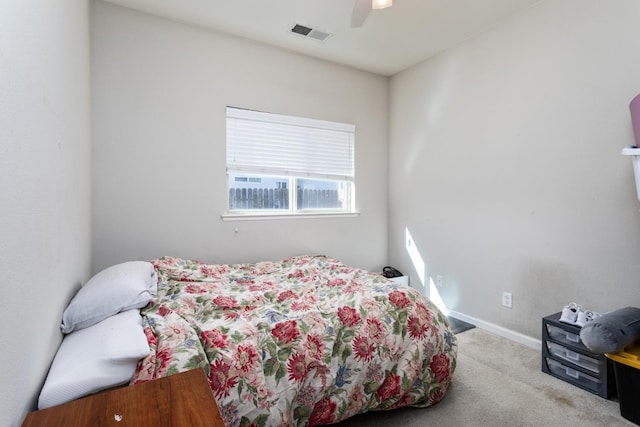 bedroom with light carpet, a ceiling fan, visible vents, and baseboards