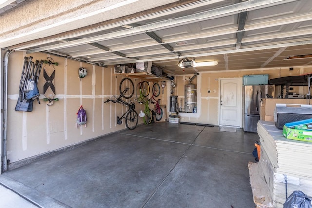 garage with a garage door opener, freestanding refrigerator, and secured water heater