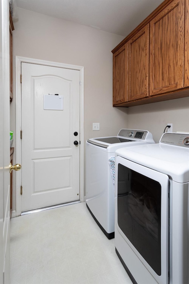 laundry area featuring cabinet space, washing machine and dryer, and light floors