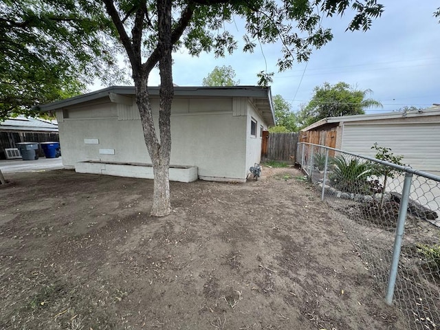 view of home's exterior with stucco siding and fence