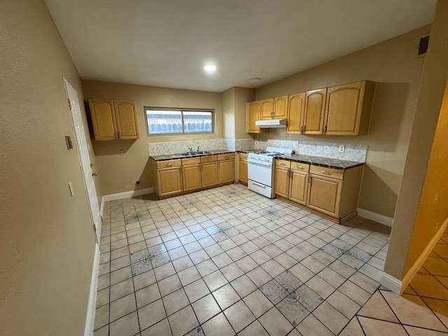 kitchen featuring sink, light tile patterned floors, light brown cabinets, and gas range gas stove