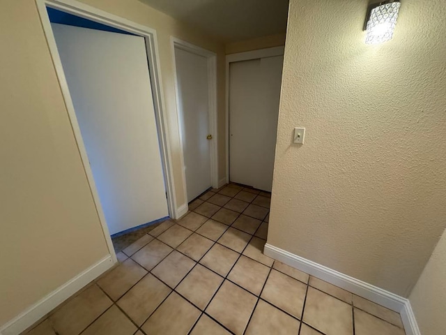 hall featuring light tile patterned floors