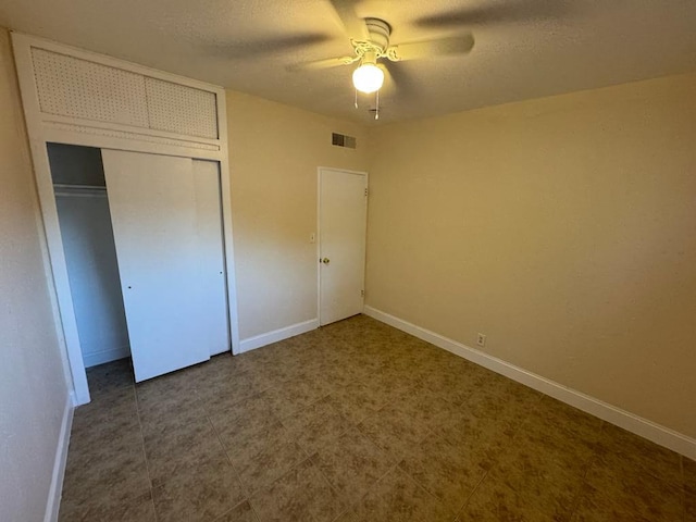 unfurnished bedroom with a textured ceiling, a closet, and ceiling fan