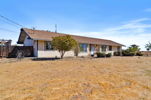 ranch-style house featuring fence