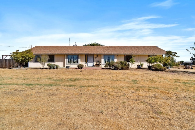 ranch-style house with a front lawn, fence, and covered porch