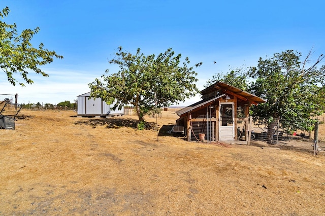 exterior space with fence, exterior structure, an outbuilding, and a storage unit