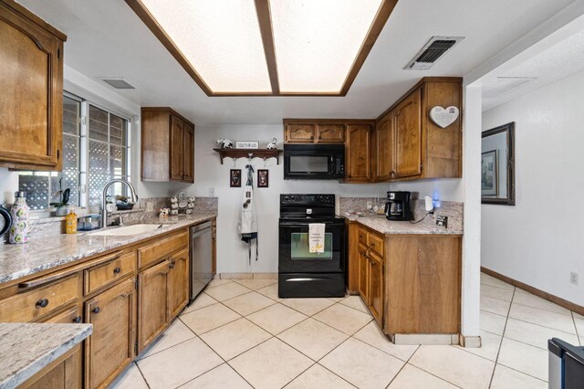 kitchen featuring visible vents, brown cabinets, a sink, light countertops, and black appliances