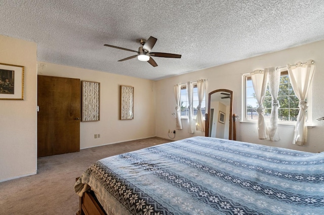 carpeted bedroom with a ceiling fan, a textured ceiling, and multiple windows