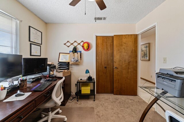 office area with a textured ceiling, visible vents, ceiling fan, and carpet
