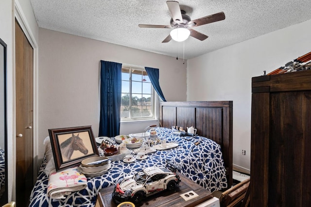 bedroom with a ceiling fan and a textured ceiling