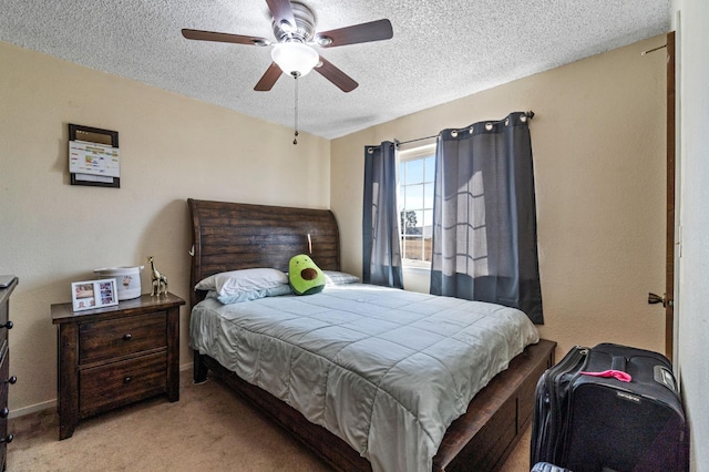 carpeted bedroom featuring baseboards, ceiling fan, and a textured ceiling