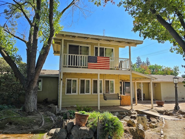 rear view of house with a patio and a balcony