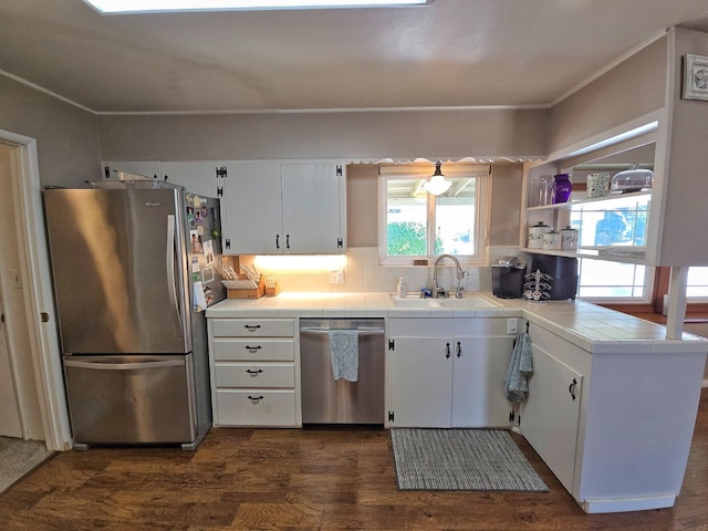 kitchen featuring sink, white cabinetry, stainless steel appliances, dark hardwood / wood-style floors, and tile counters