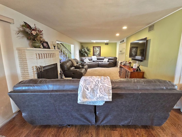 living room featuring hardwood / wood-style flooring, a fireplace, and built in shelves