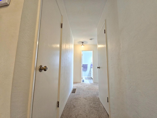 hallway with light colored carpet