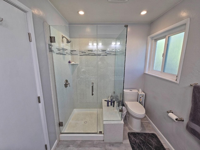 bathroom featuring toilet and a shower with door