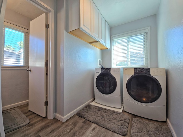 laundry room featuring cabinets, hardwood / wood-style floors, and washing machine and dryer