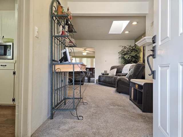 carpeted living room featuring a skylight