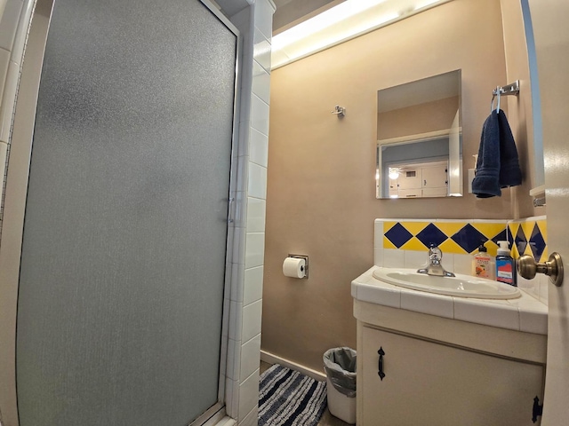 bathroom featuring tasteful backsplash, vanity, and walk in shower