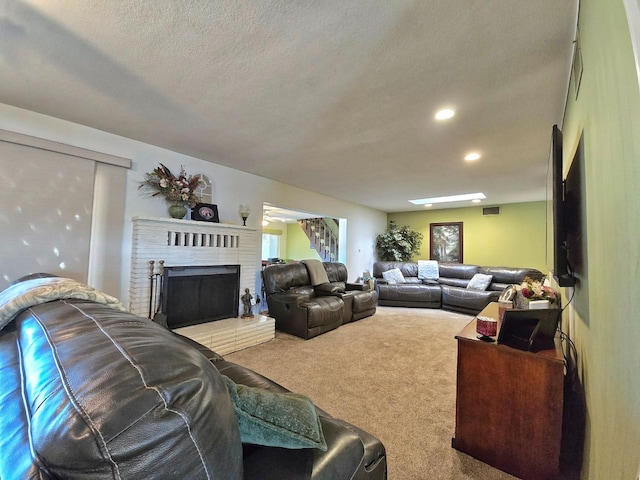 living room featuring a fireplace, a textured ceiling, and carpet