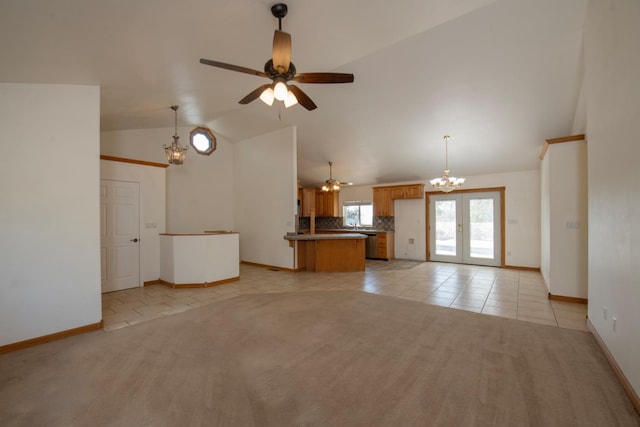 unfurnished living room featuring lofted ceiling, french doors, light tile patterned flooring, and ceiling fan with notable chandelier