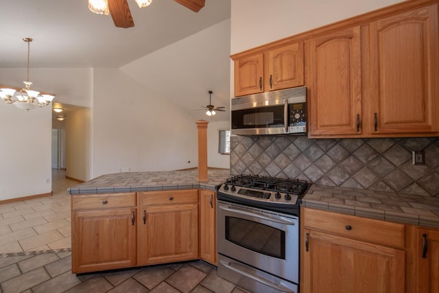 kitchen featuring backsplash, lofted ceiling, stainless steel appliances, and tile counters