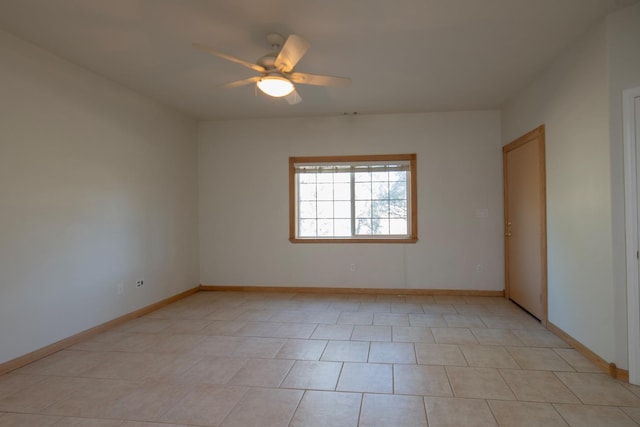 tiled spare room with ceiling fan