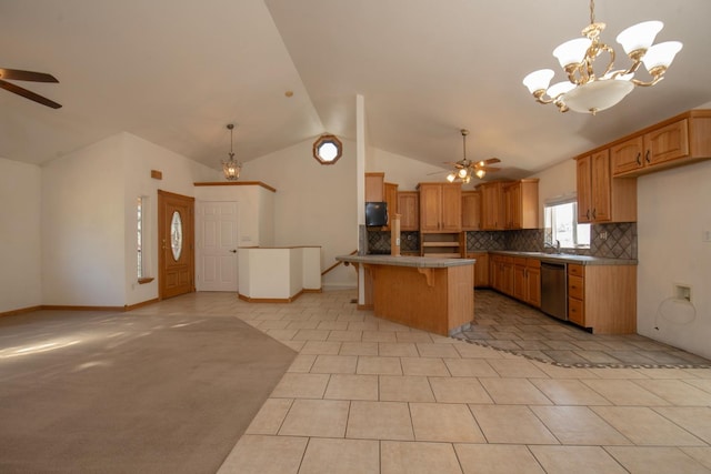 kitchen featuring vaulted ceiling, dishwasher, light tile patterned flooring, ceiling fan with notable chandelier, and a center island