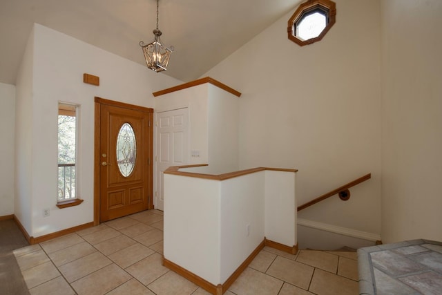 entryway with high vaulted ceiling and light tile patterned floors