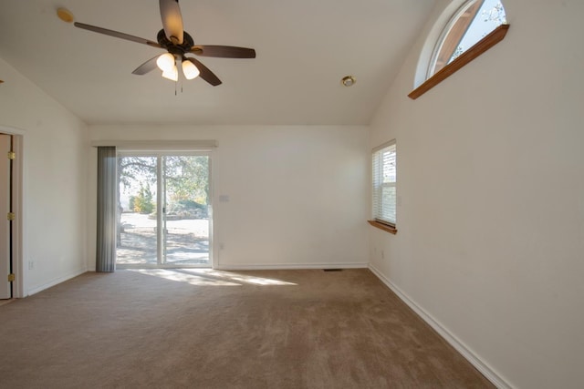 carpeted empty room with ceiling fan, high vaulted ceiling, and plenty of natural light