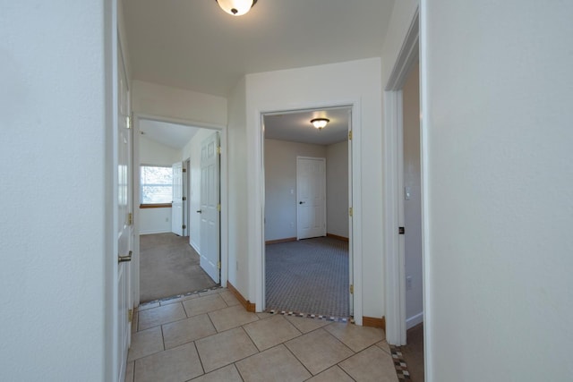 corridor featuring light carpet and lofted ceiling