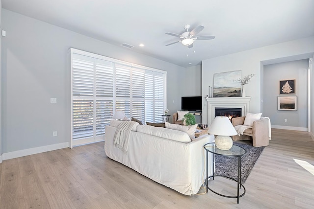 living room with light hardwood / wood-style flooring and ceiling fan