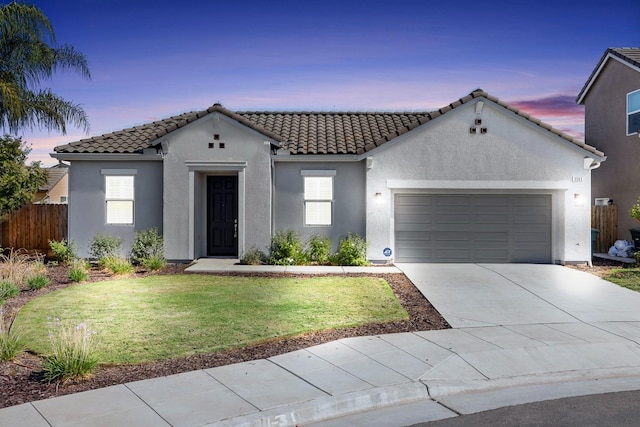 mediterranean / spanish-style home with a garage and a lawn