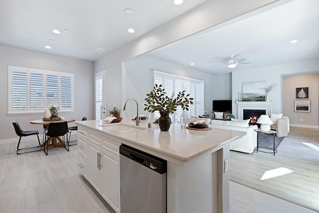 kitchen featuring a center island with sink, sink, dishwasher, and a wealth of natural light