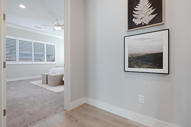 interior space with ornamental molding and light hardwood / wood-style flooring