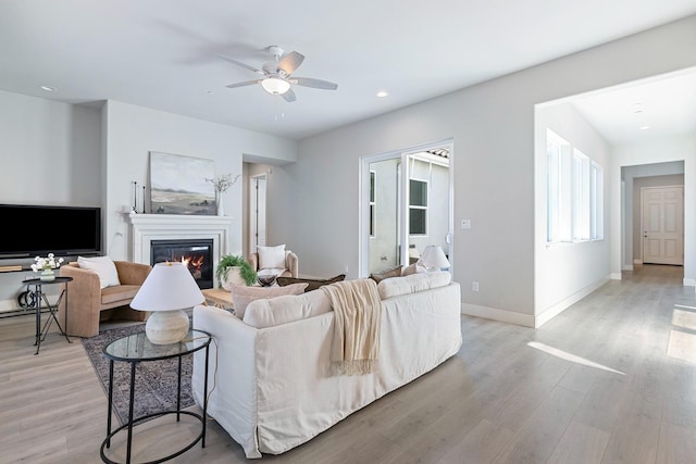 living room featuring light hardwood / wood-style floors and ceiling fan