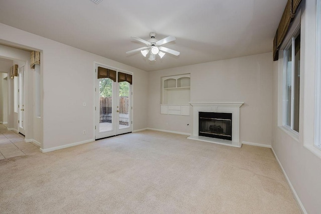 unfurnished living room with ceiling fan, light colored carpet, and built in features