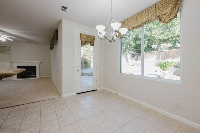 doorway to outside featuring light tile patterned flooring and ceiling fan with notable chandelier