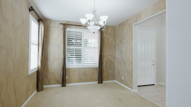 carpeted empty room with a chandelier