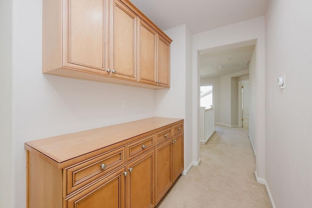 hall with light colored carpet